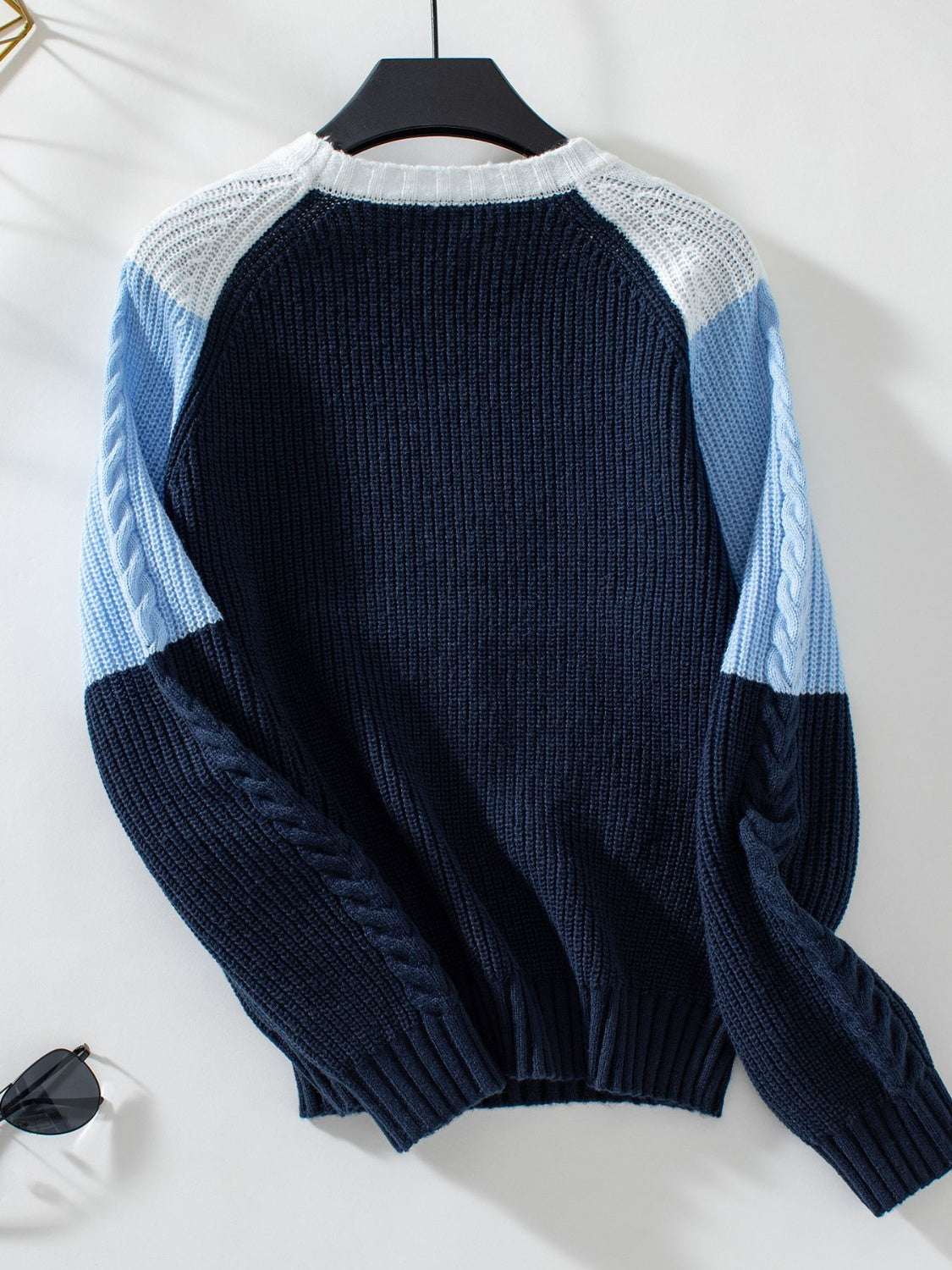 Color block round neck long sleeve sweater with blue and white design.