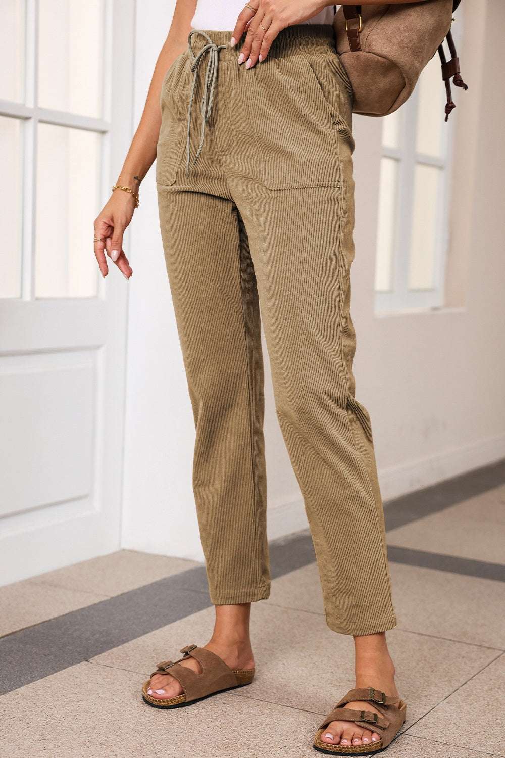 Drawstring straight pants with pockets in beige, 100% polyester.