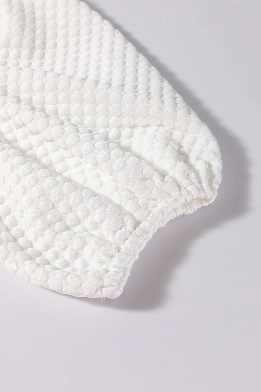 Textured round neck puff sleeve blouse detail showing fabric pattern.