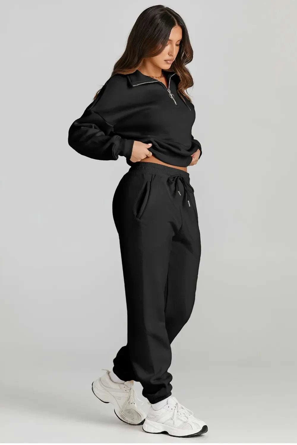 Quarter zip top with drawstring pants in black, two-piece active set.