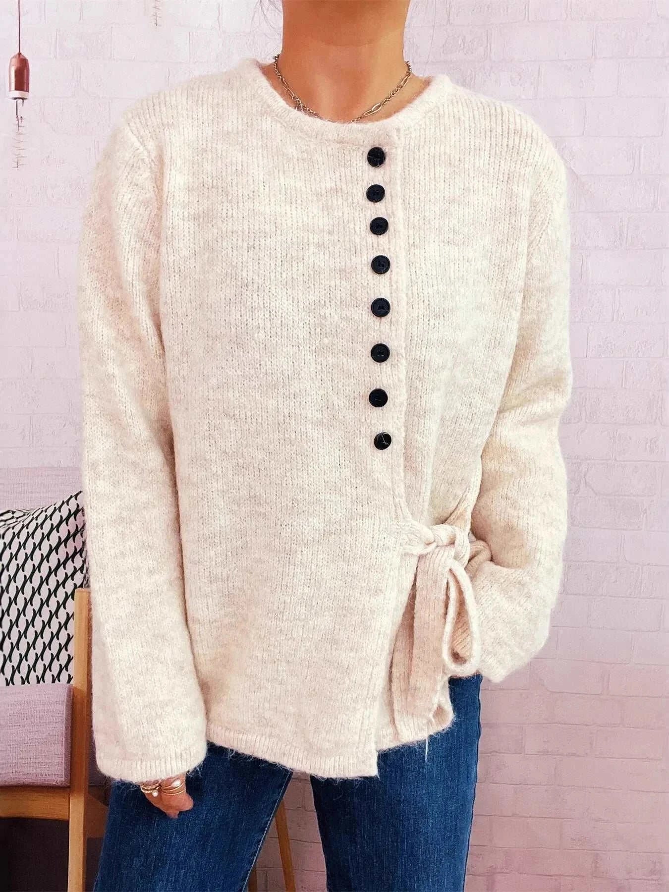 Cream button-front side-tie sweater with long sleeves and slight stretch, made of 100% polyester.