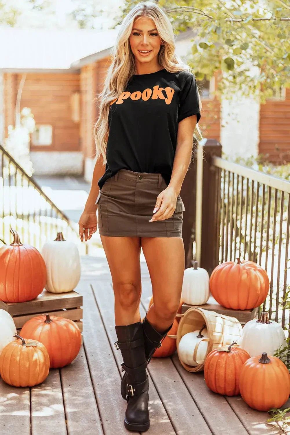 SPOOKY Round Neck Short Sleeve T-Shirt with pumpkins on a wooden deck.