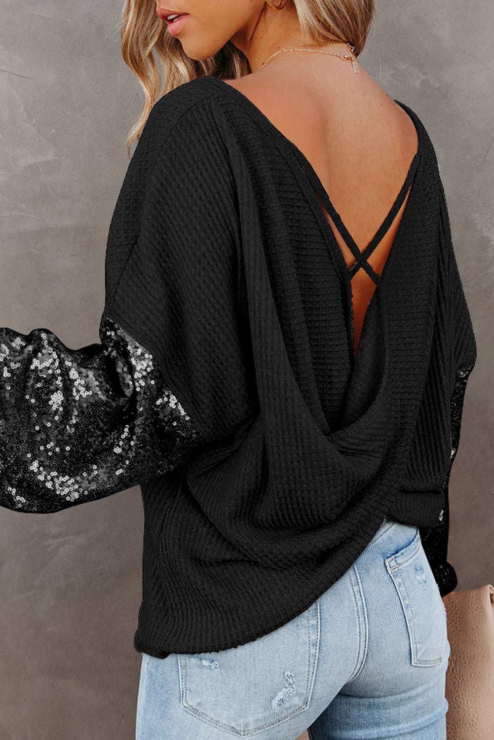 Sequin waffle-knit blouse with open back and sequin sleeves.