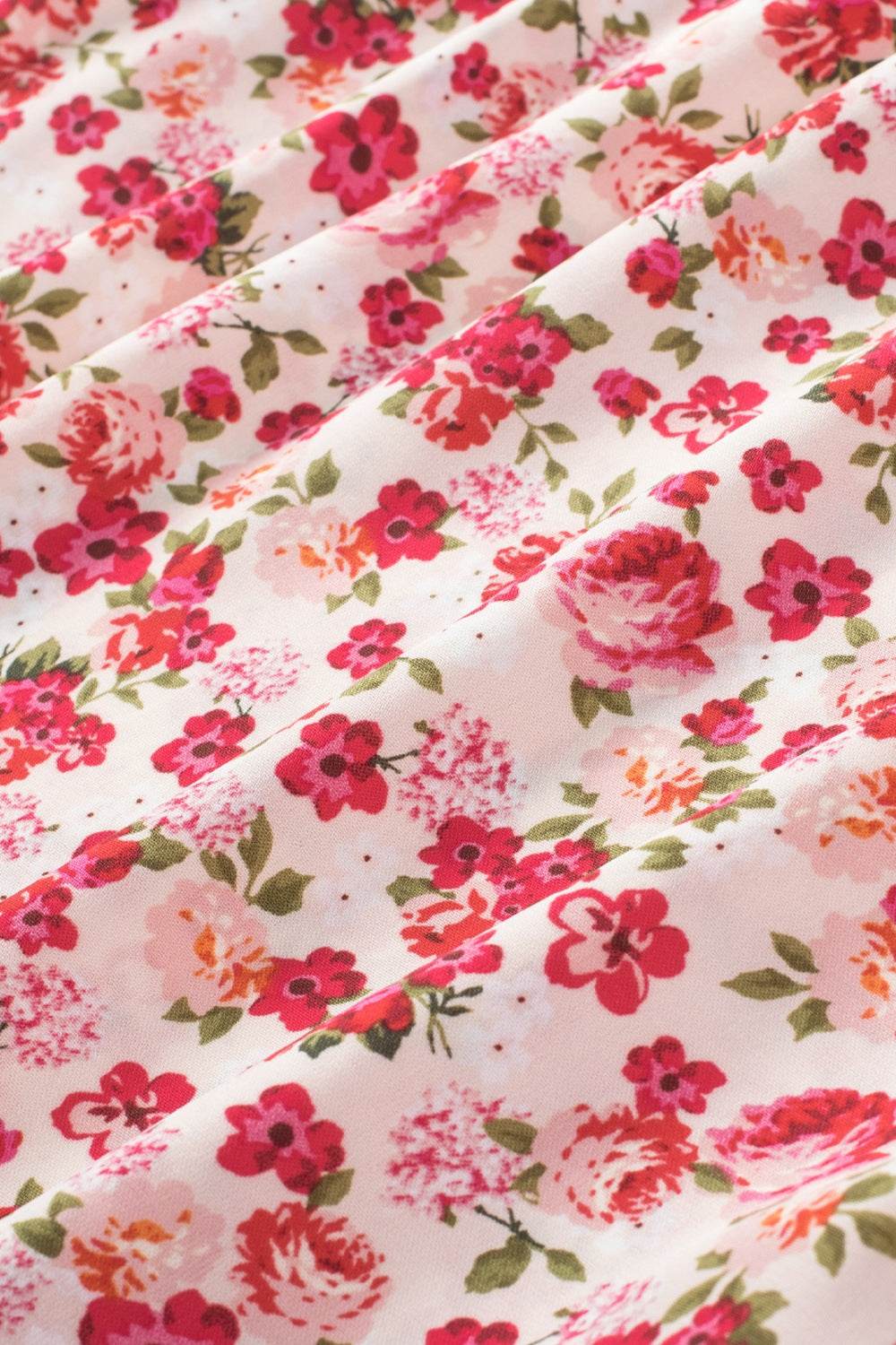 Ruffled floral fabric with colorful blooms on a blouse.