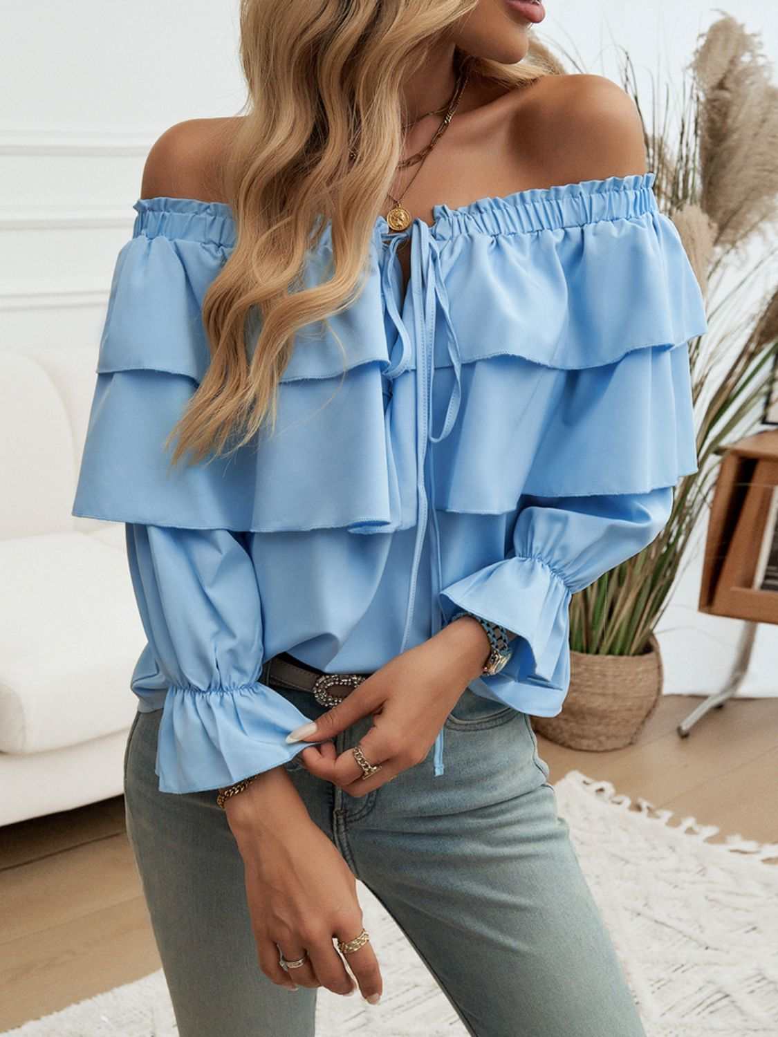 Off-shoulder flounce sleeve blouse with ruffled drawstring design in light blue.