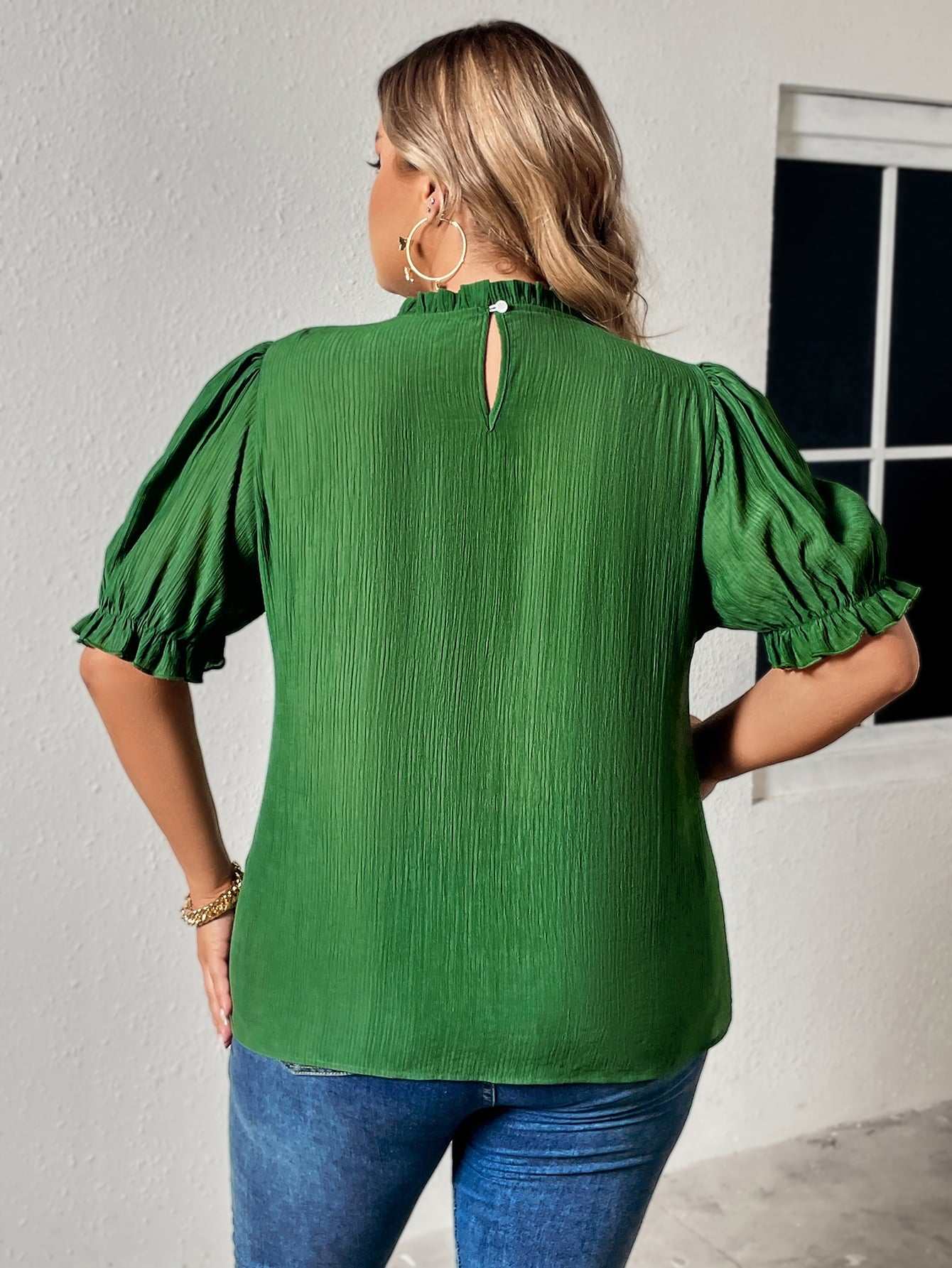 Plus size green blouse with round neck and puff sleeves.