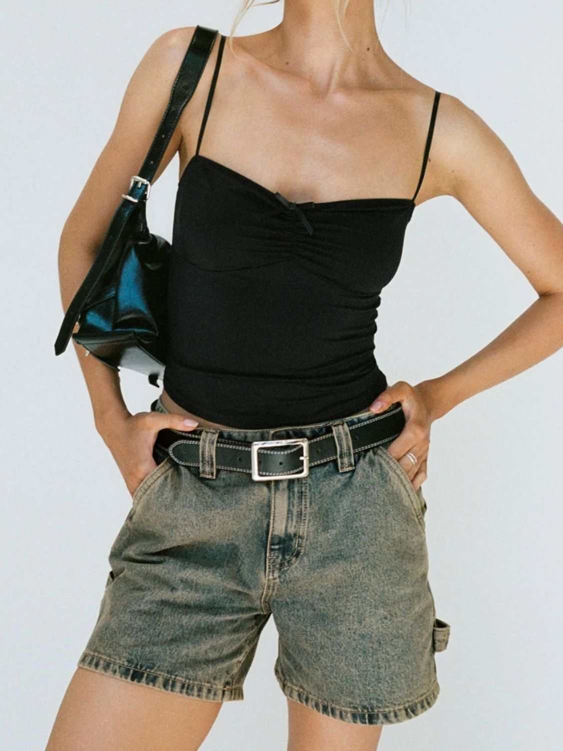 Washed high rise denim shorts with pockets and belt, styled with a black top.