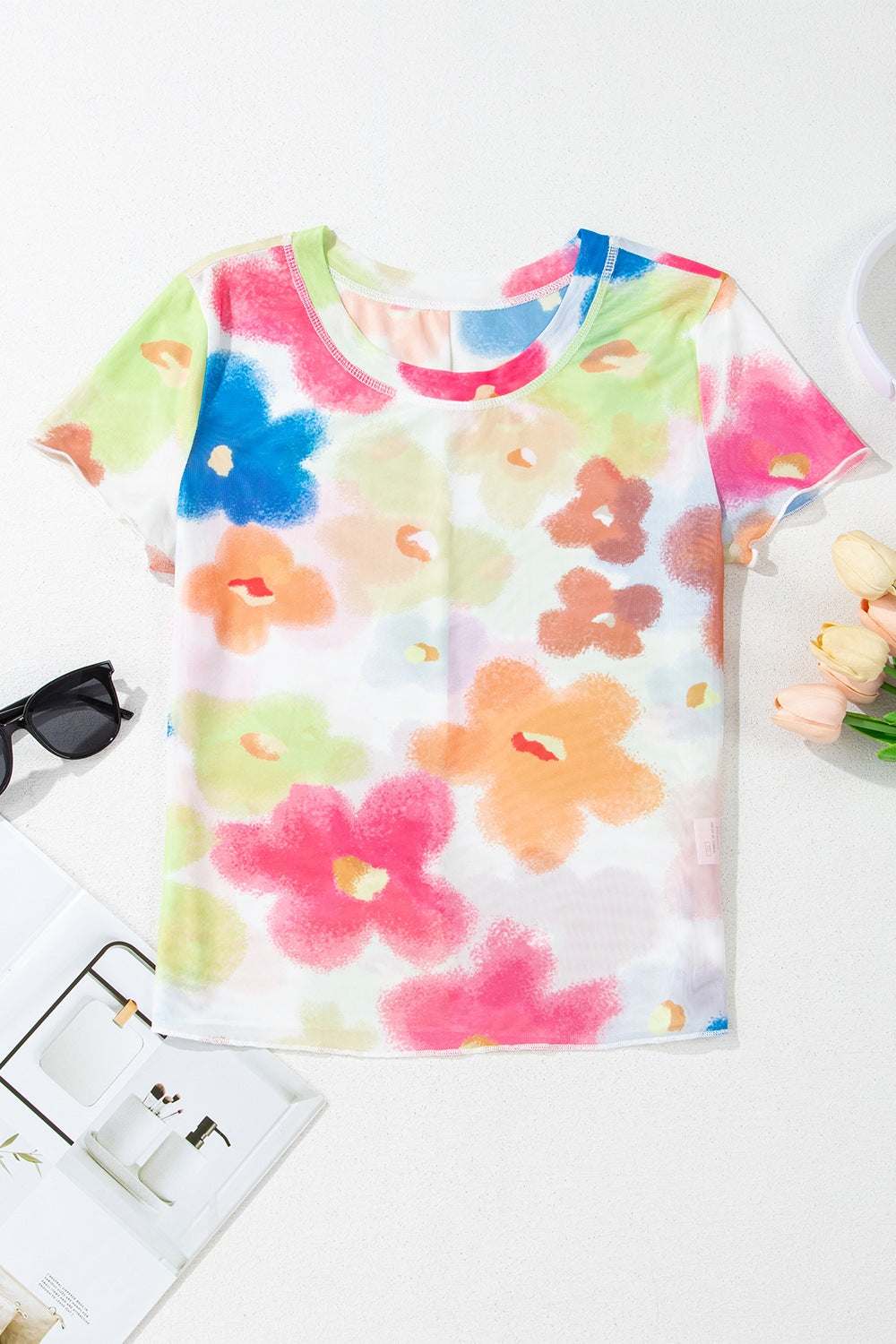 Printed round neck short sleeve blouse with colorful floral pattern.