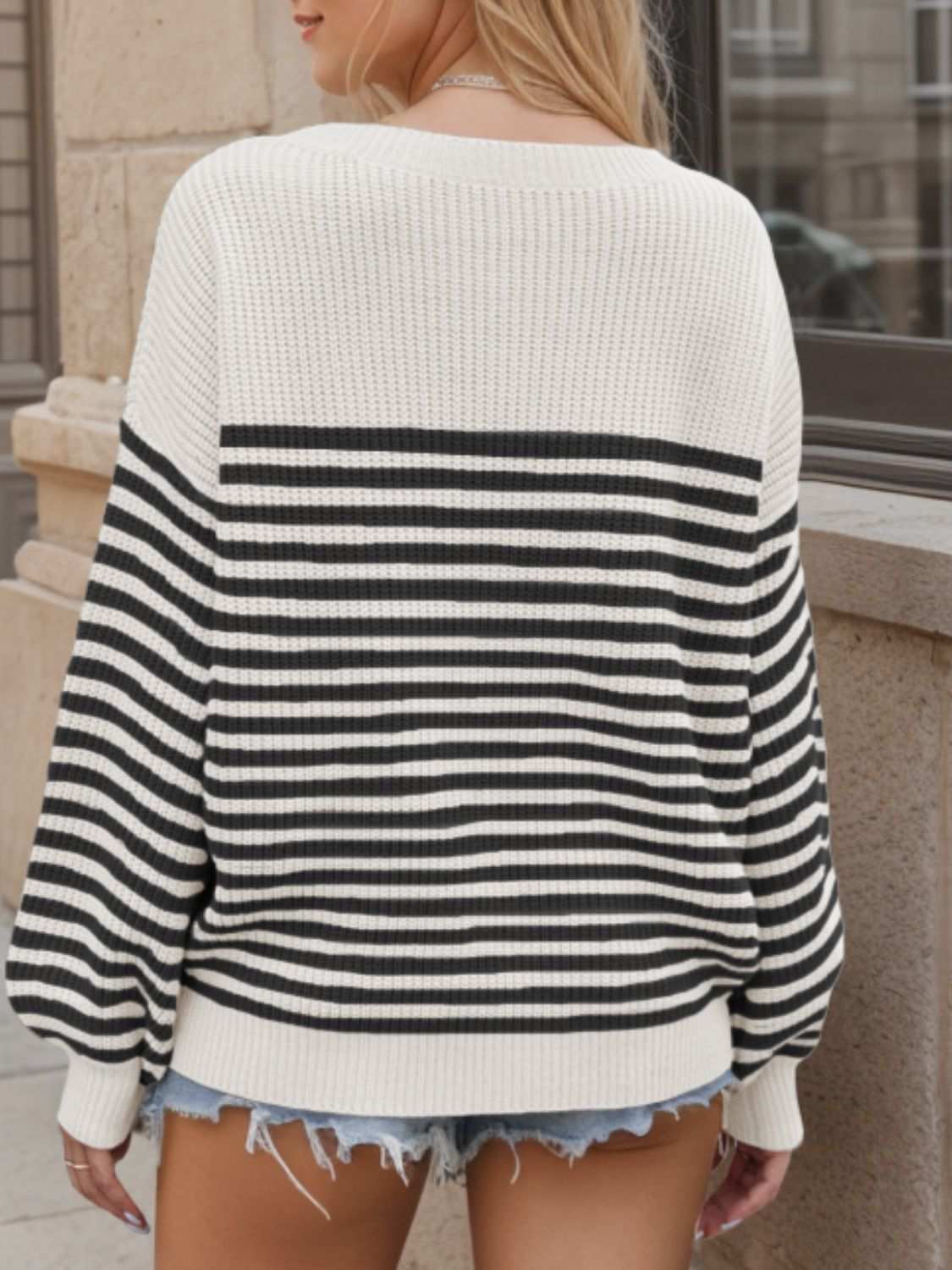 Striped round neck long sleeve sweater in black and white acrylic, shown from the back.