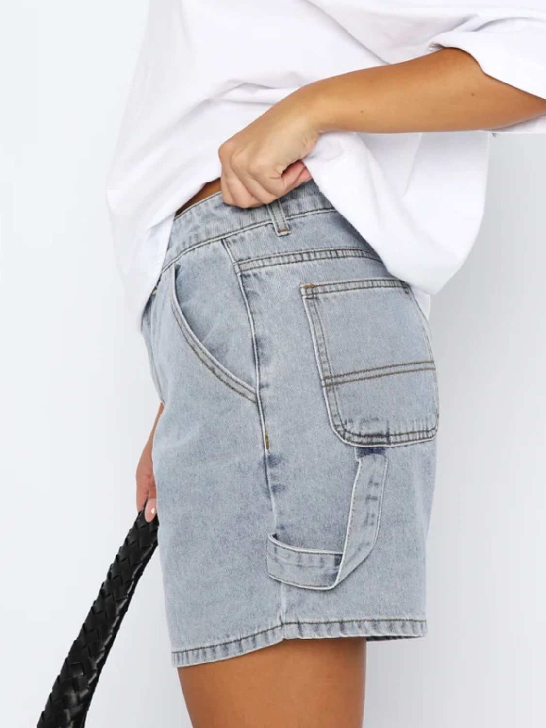 Washed high rise denim shorts with pockets, shown in side view.