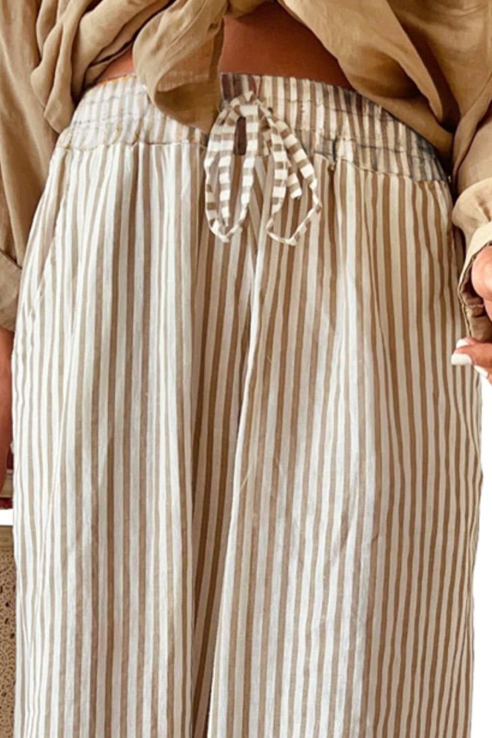 Pocketed striped wide leg pants with drawstring detail.