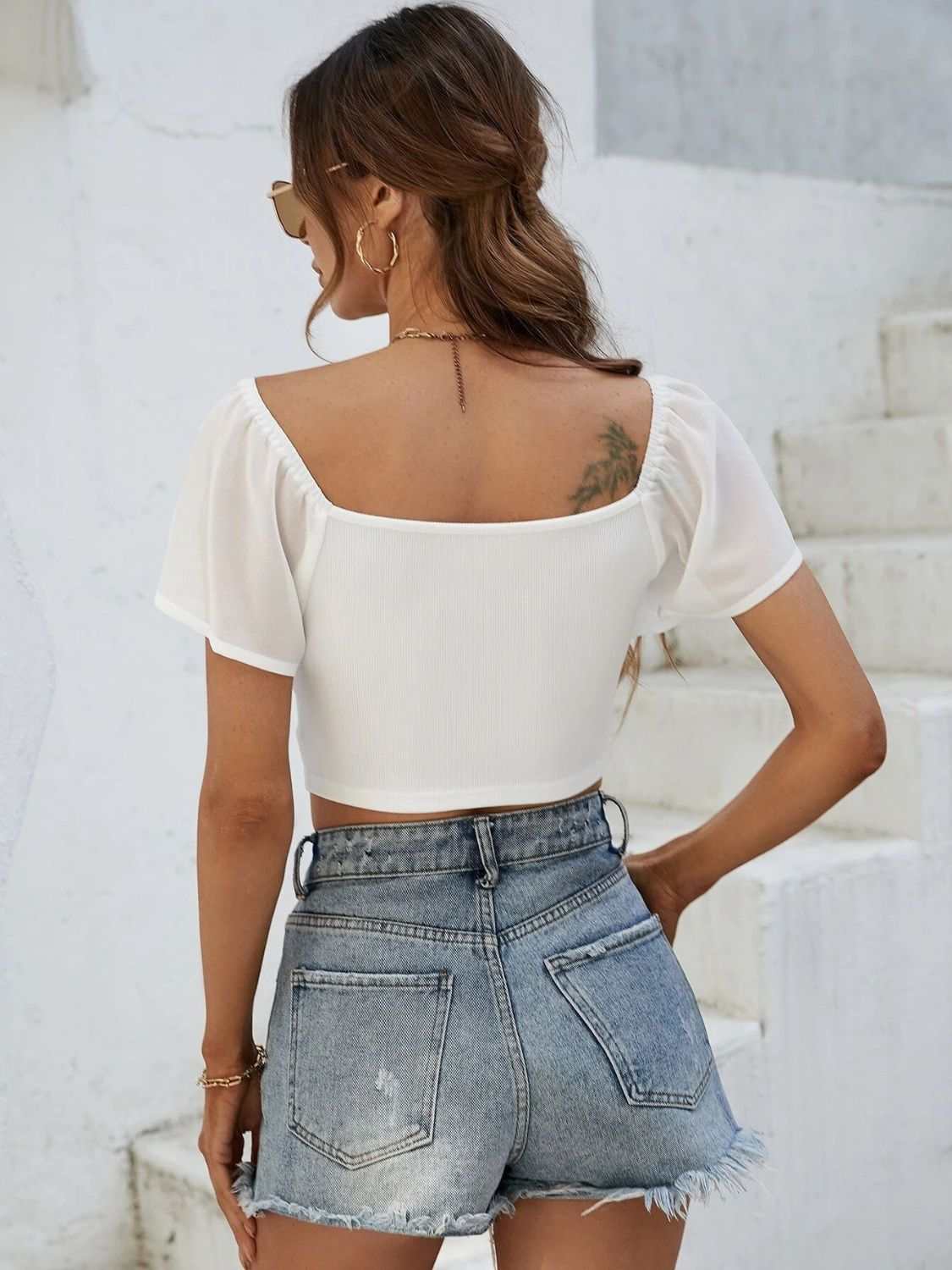 White drawstring short sleeve crop top, back view, paired with denim shorts.