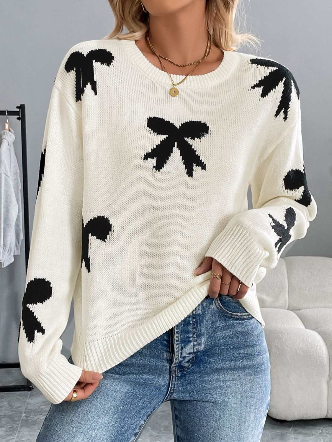 Perfee Bow Graphic Round Neck Long Sleeve Sweater in white with black bow designs.