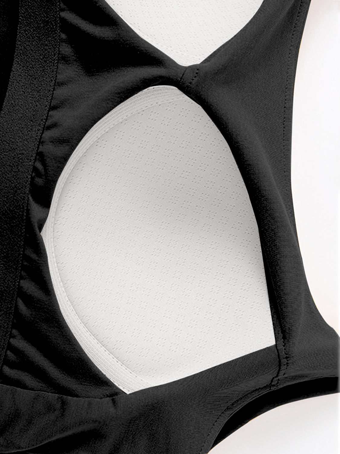 Scoop neck cropped cami with chest pads, black fabric close-up.