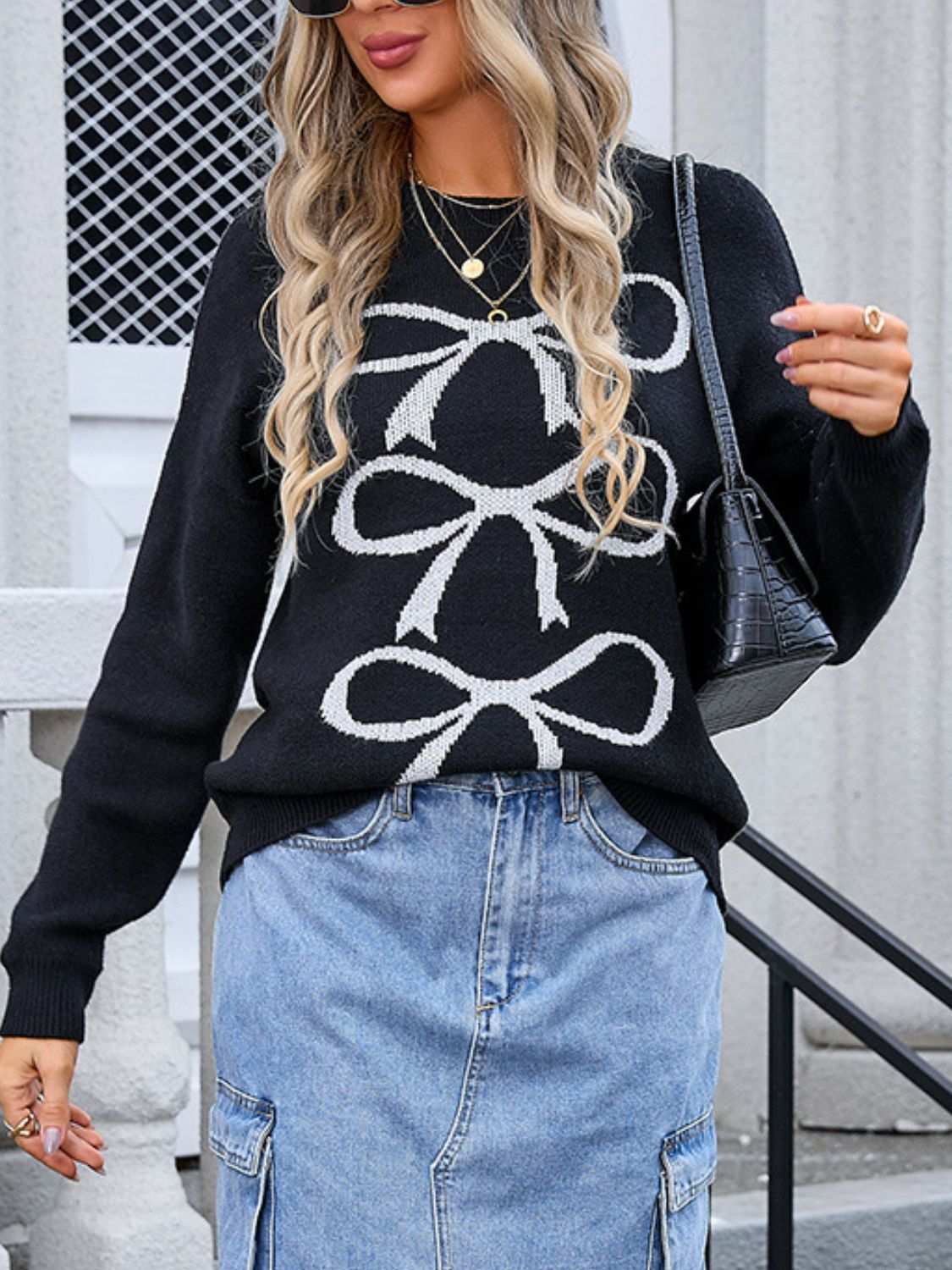 Angel Wings Bow Graphic Round Neck Long Sleeve Sweater in black with white bow design, paired with a denim skirt.