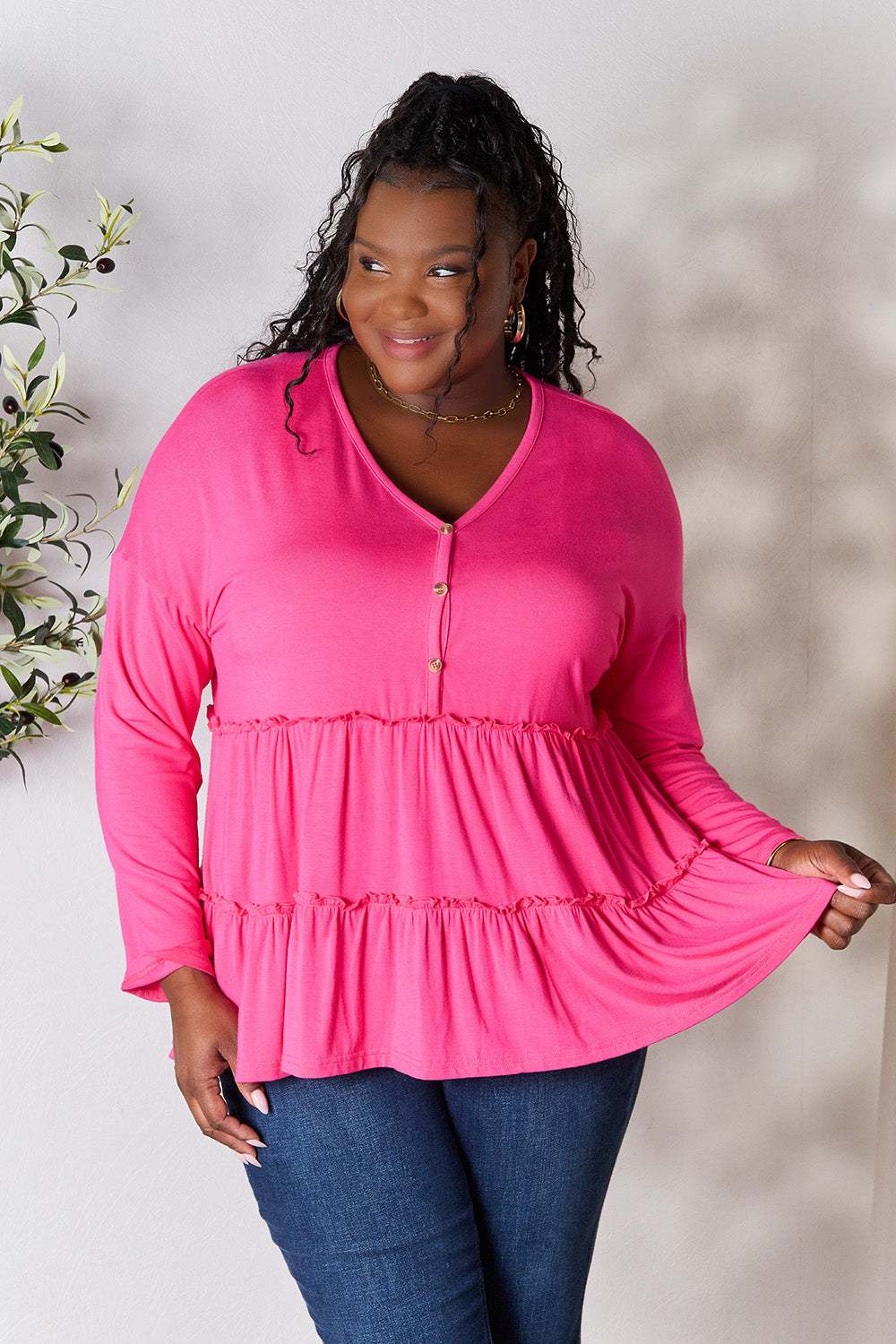 Half Button Long Sleeve Ruffle Hem Blouse in pink worn by model.
