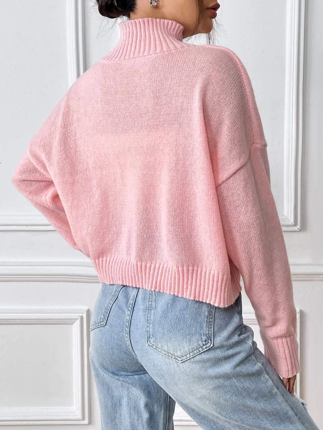 Pink bow turtleneck long sleeve sweater with slightly stretchy polyester fabric.