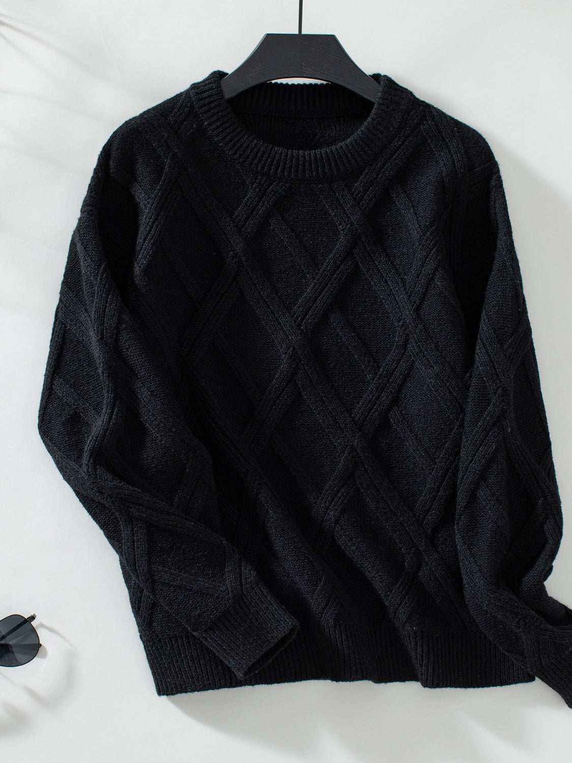 Geometric round neck long sleeve sweater in black with textured pattern.