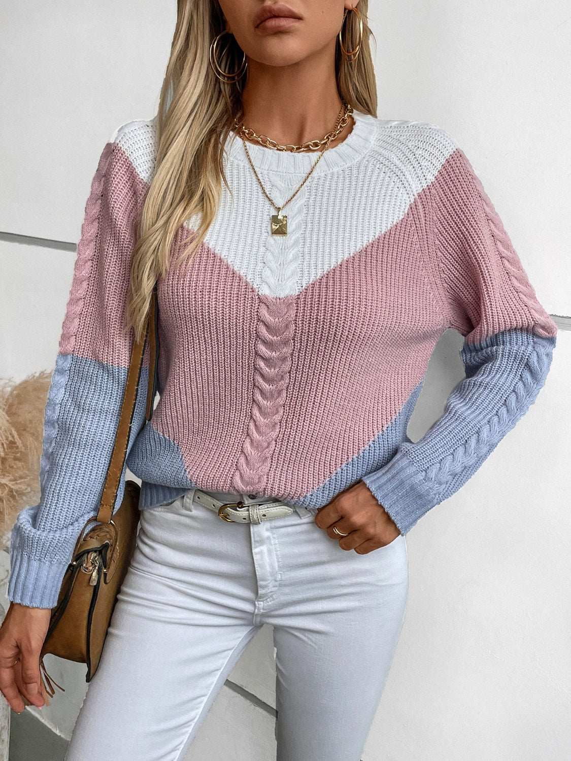 Color block round neck long sleeve sweater in pink, blue, and white with braided patterns, slightly stretchy, worn with white pants.