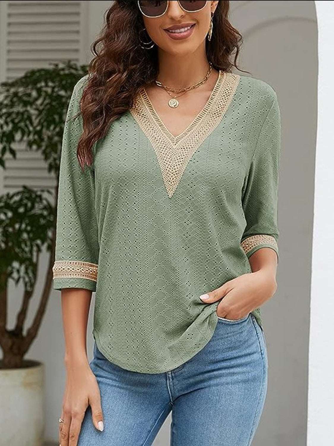 V-Neck Eyelet Blouse in green with lace trim, worn by a model, featuring a basic opaque style made of polyester.