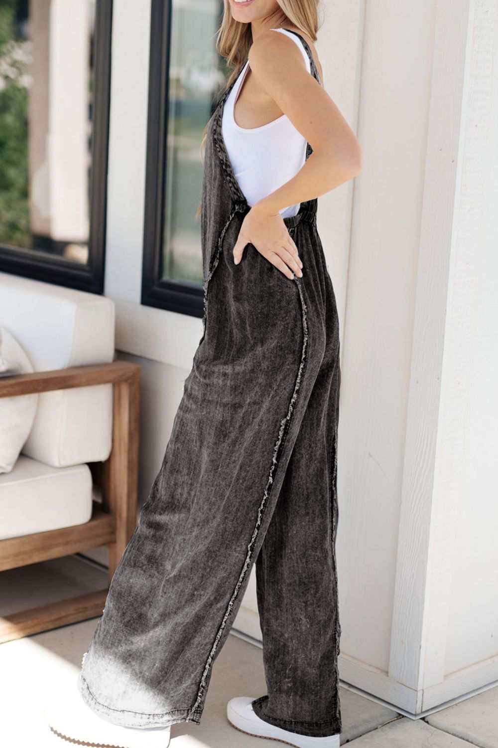 Frayed exposed seam wide leg denim overalls with raw hem.