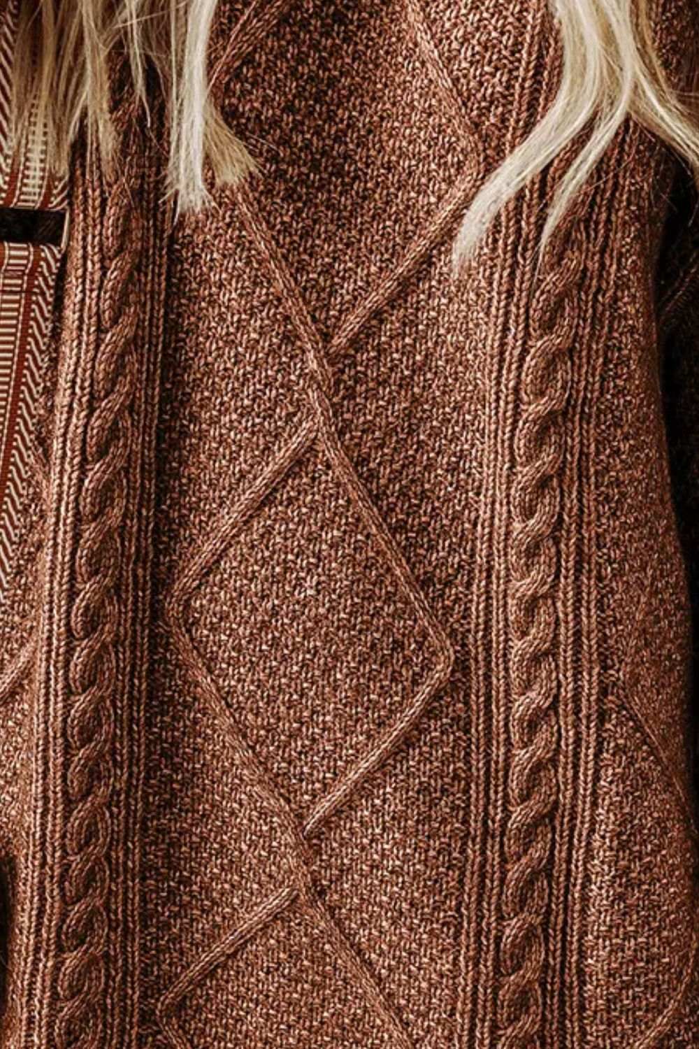 Cable-knit round neck sweater dress close-up showing texture.
