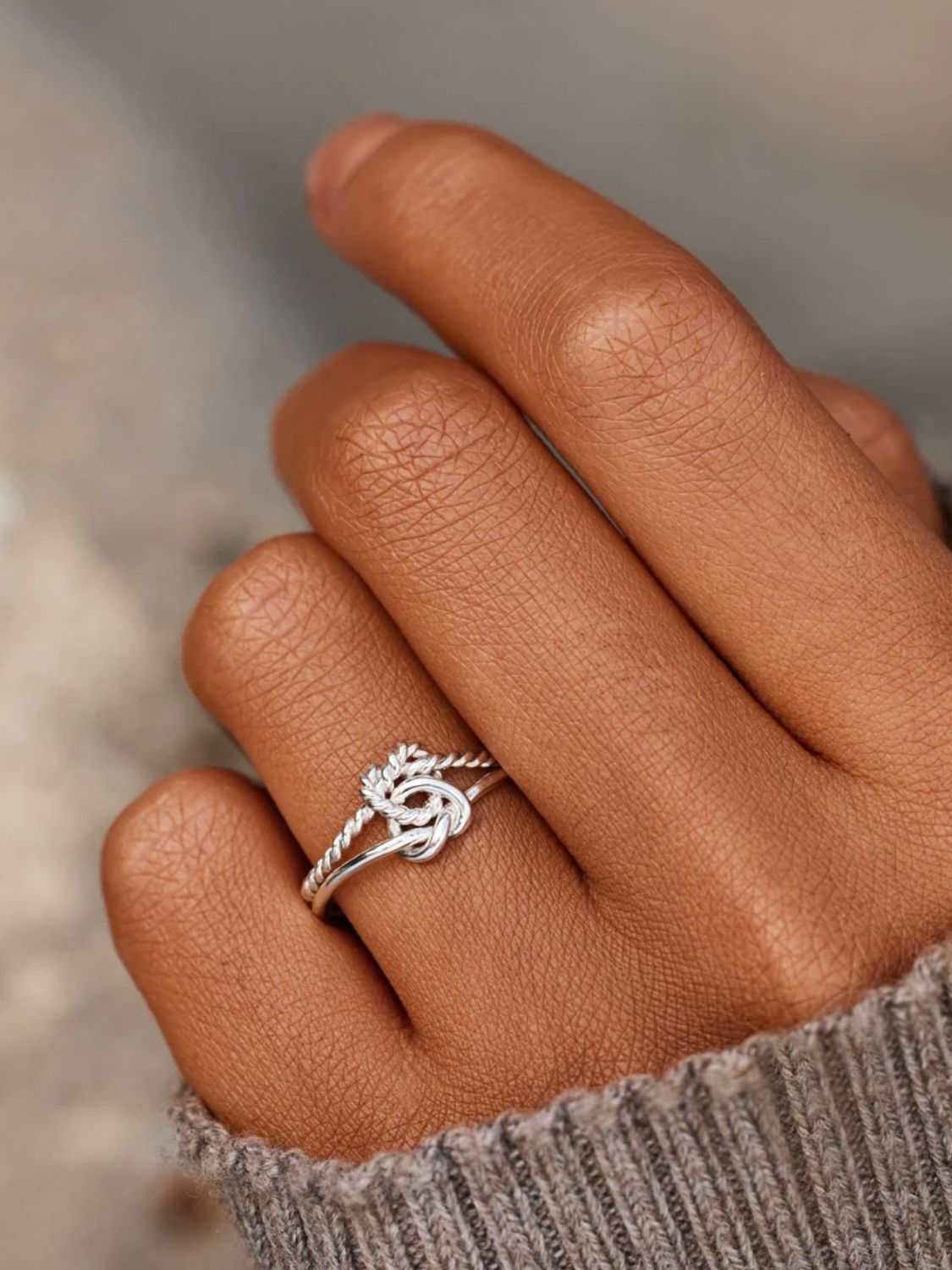 925 Sterling Silver Knotted Ring on hand, adjustable design, elegant jewelry accessory.
