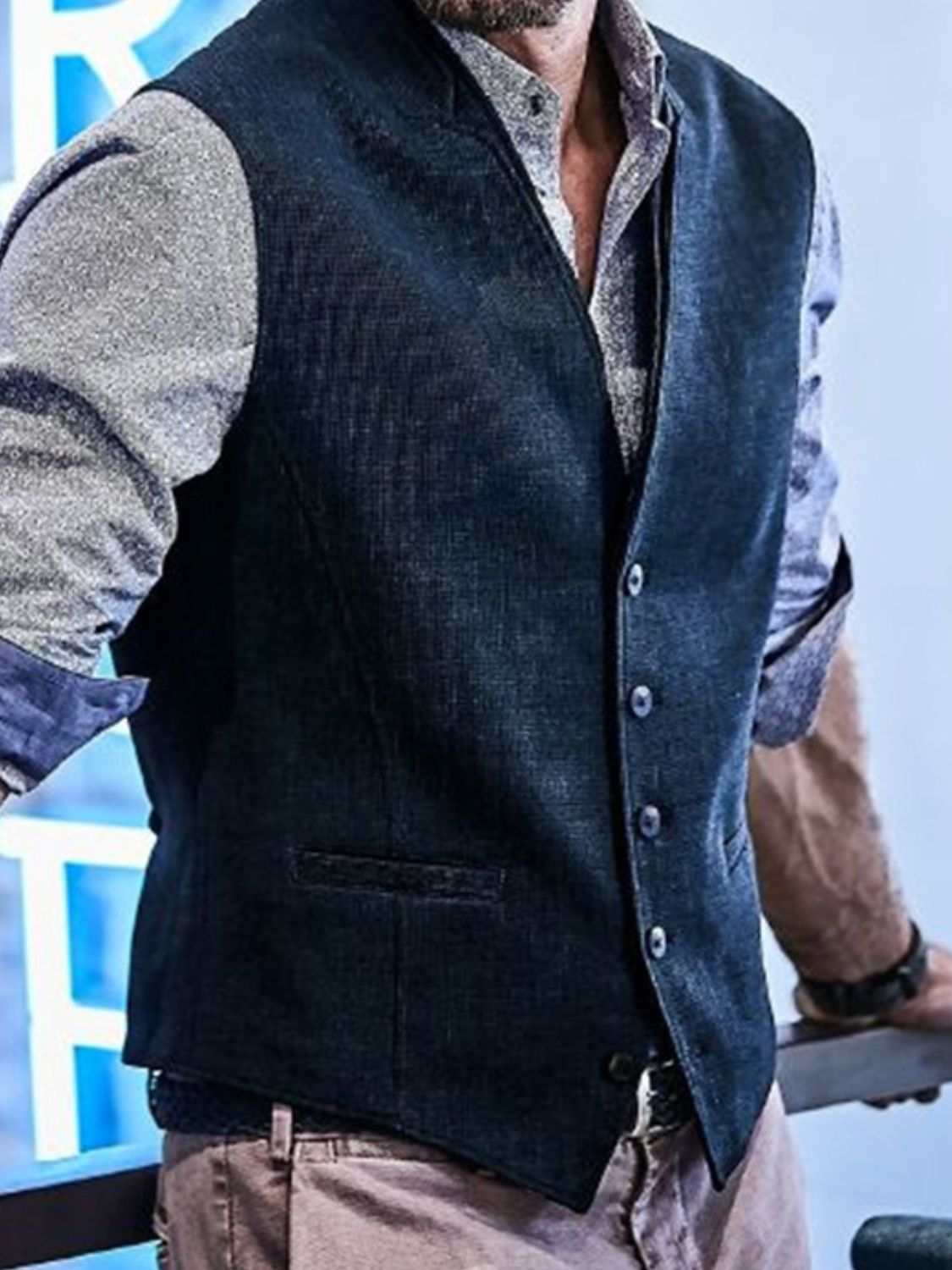 Men's full-size button-down vest in dark fabric with shirt underneath.