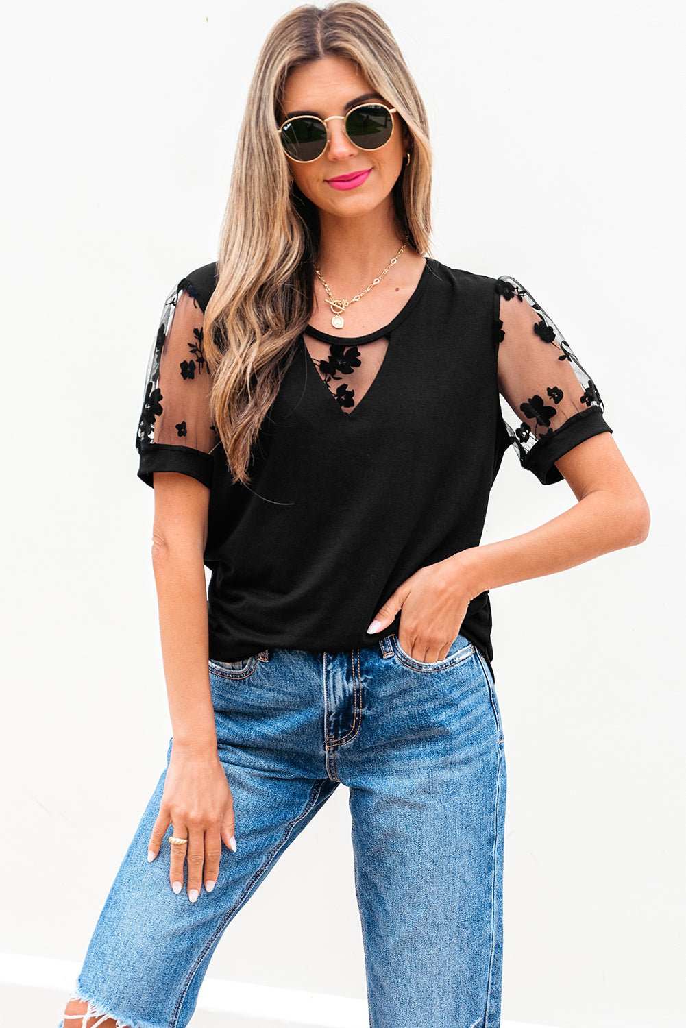 Black crew neck t-shirt with floral lace patchwork mesh puff sleeves, styled with blue jeans