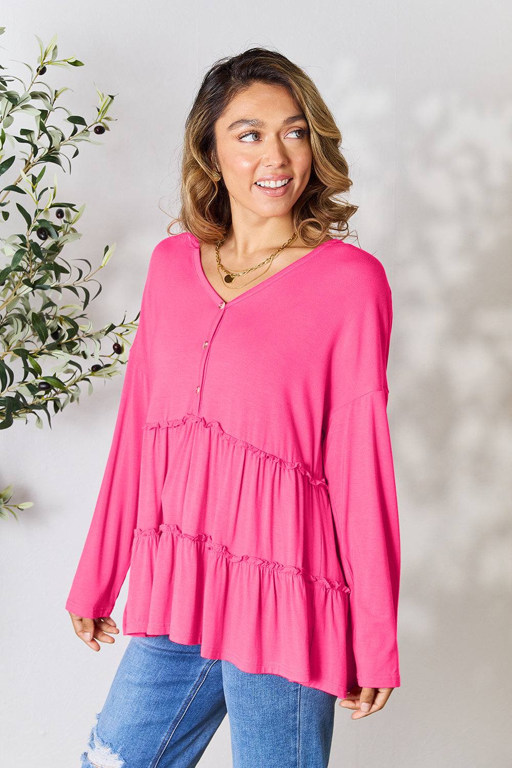 Pink half button long sleeve ruffle hem blouse with jeans.