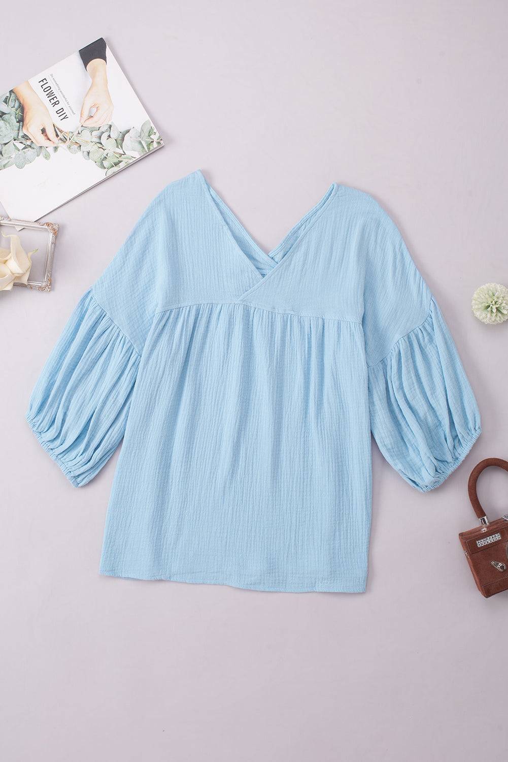 Casual solid V-neck blouse with long dropped shoulder sleeves in light blue.
