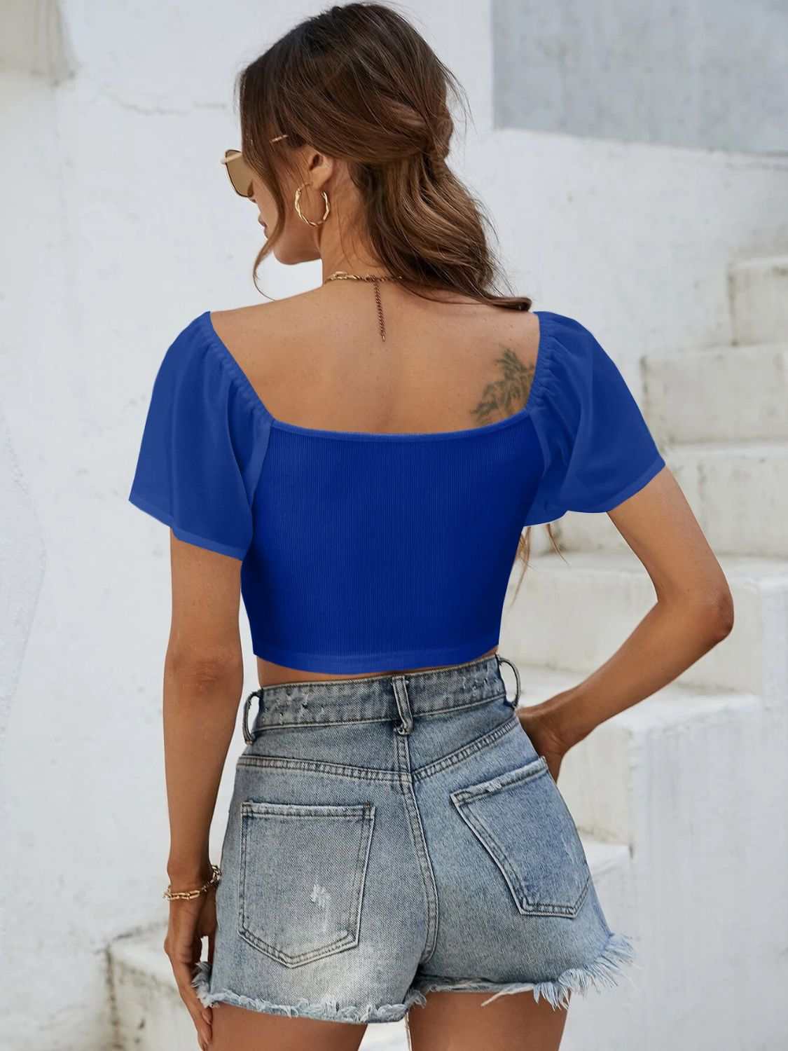 Drawstring short sleeve crop top in royal blue, shown from the back with moderate stretch material.