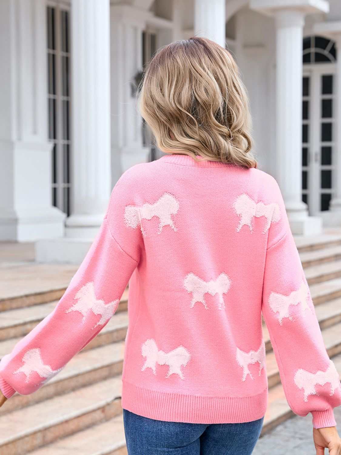 Pink Angel Wings Bow Round Neck Dropped Shoulder Sweater with white bow patterns, moderate stretch material.