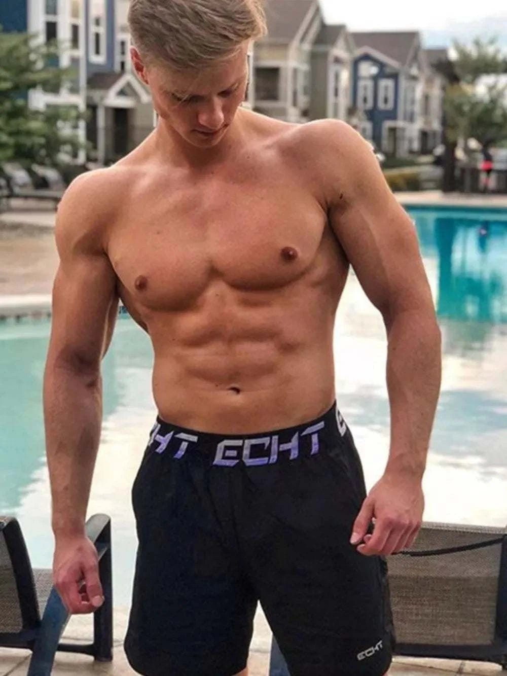 Men's Letter Elastic Waist Active Shorts by poolside, stretchy polyester-cotton blend.