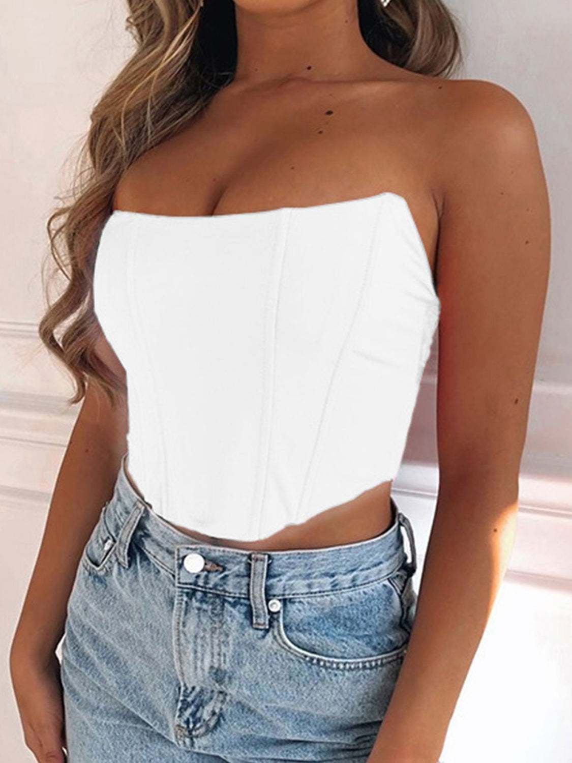 White tube cropped top made of polyester and spandex, styled with jeans.