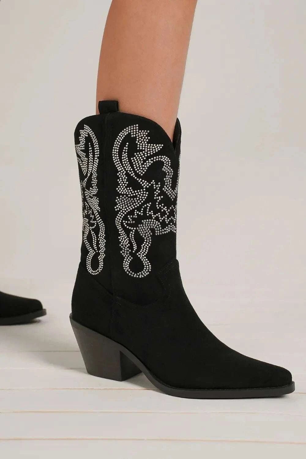 Rhinestone detail point toe boots with mid heels and suede exterior.