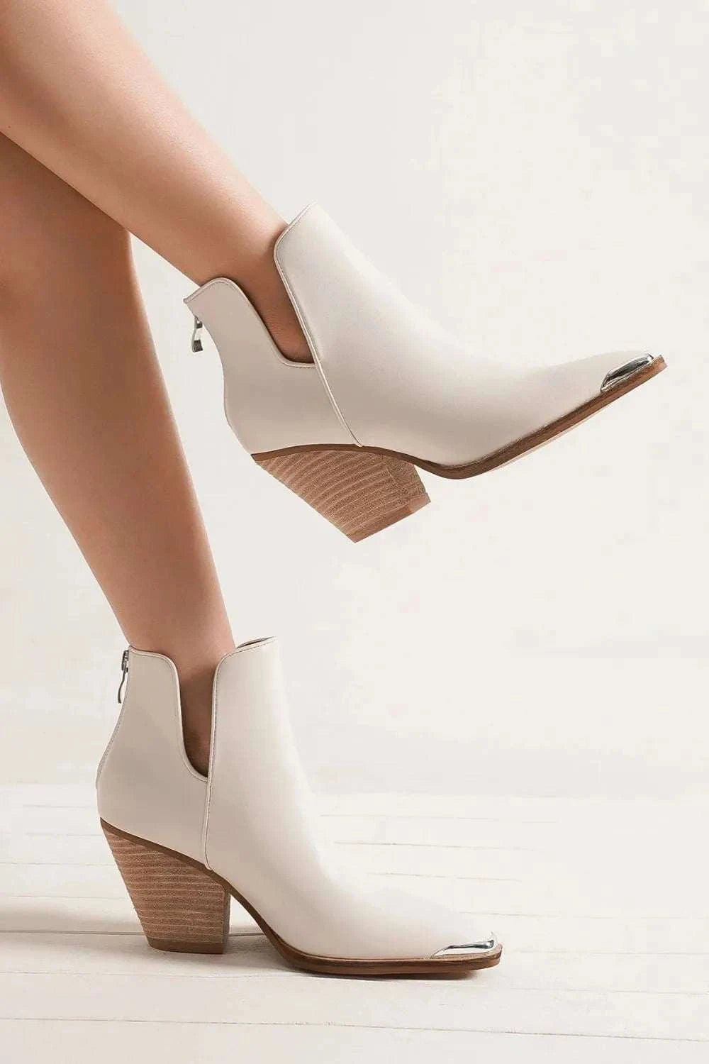 Pointed metal-tip toe block heel ankle boots in white PU leather.