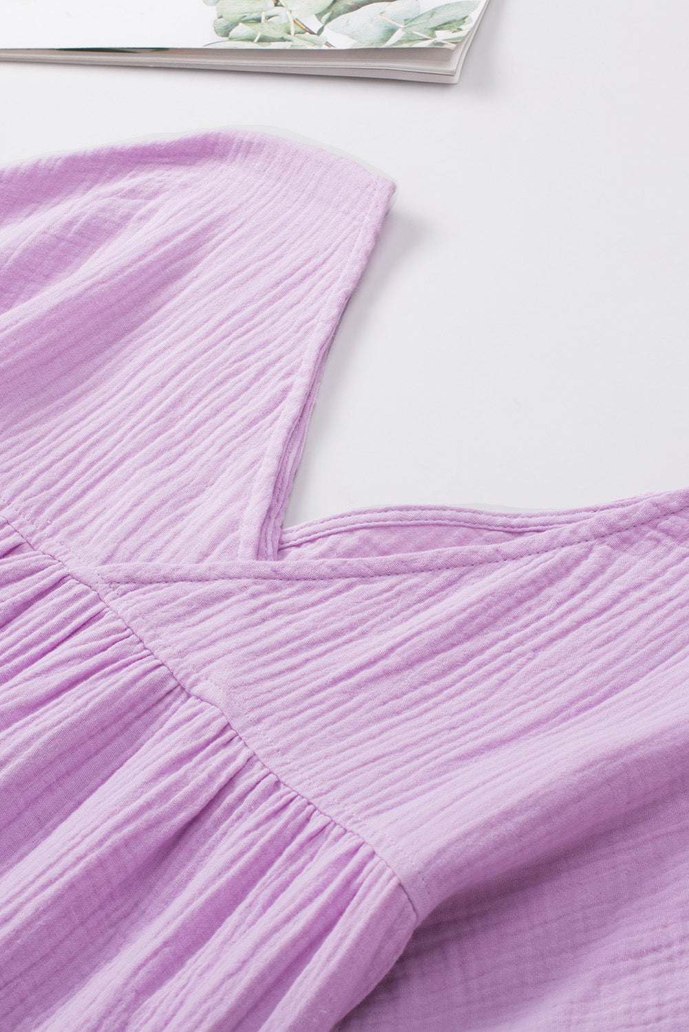 Solid purple dropped shoulder V-neck blouse in cotton fabric.