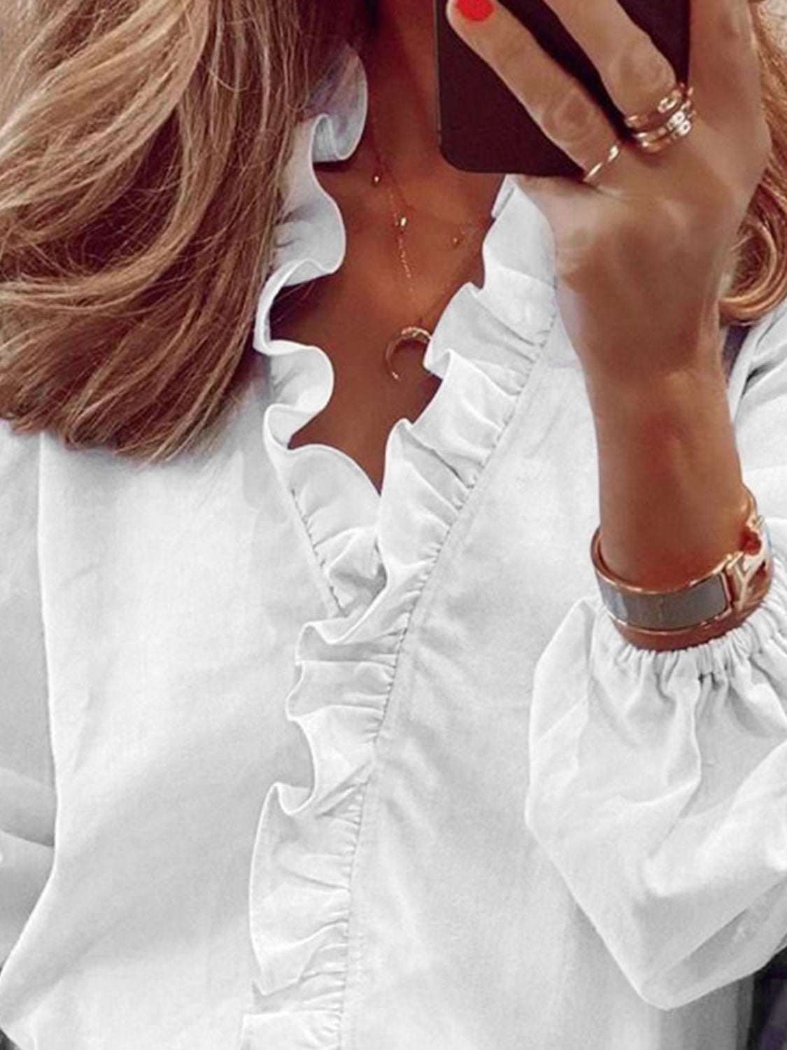 Ruffled v-neck long sleeve blouse in white with elegant detailing.