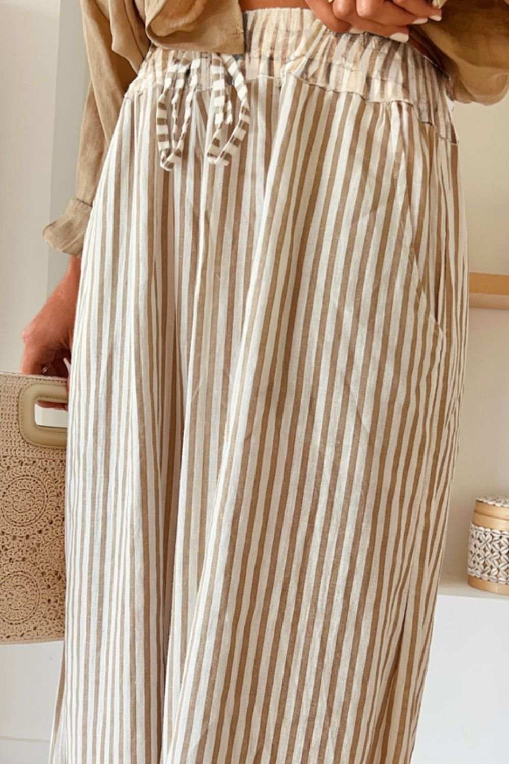 Pocketed striped wide leg pants with drawstring detail.