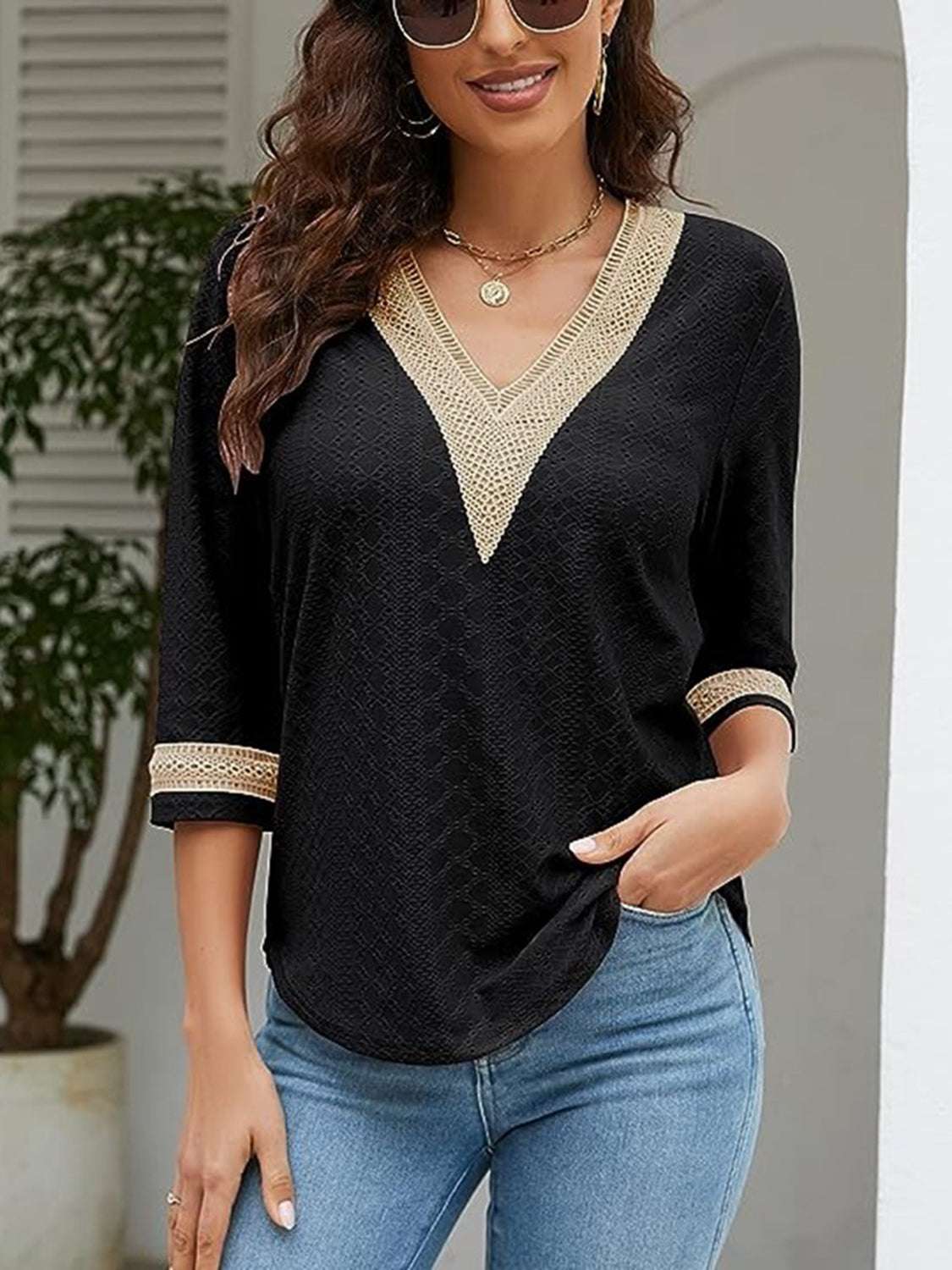 V-Neck Eyelet Blouse in black with decorative trim, styled casually with jeans.