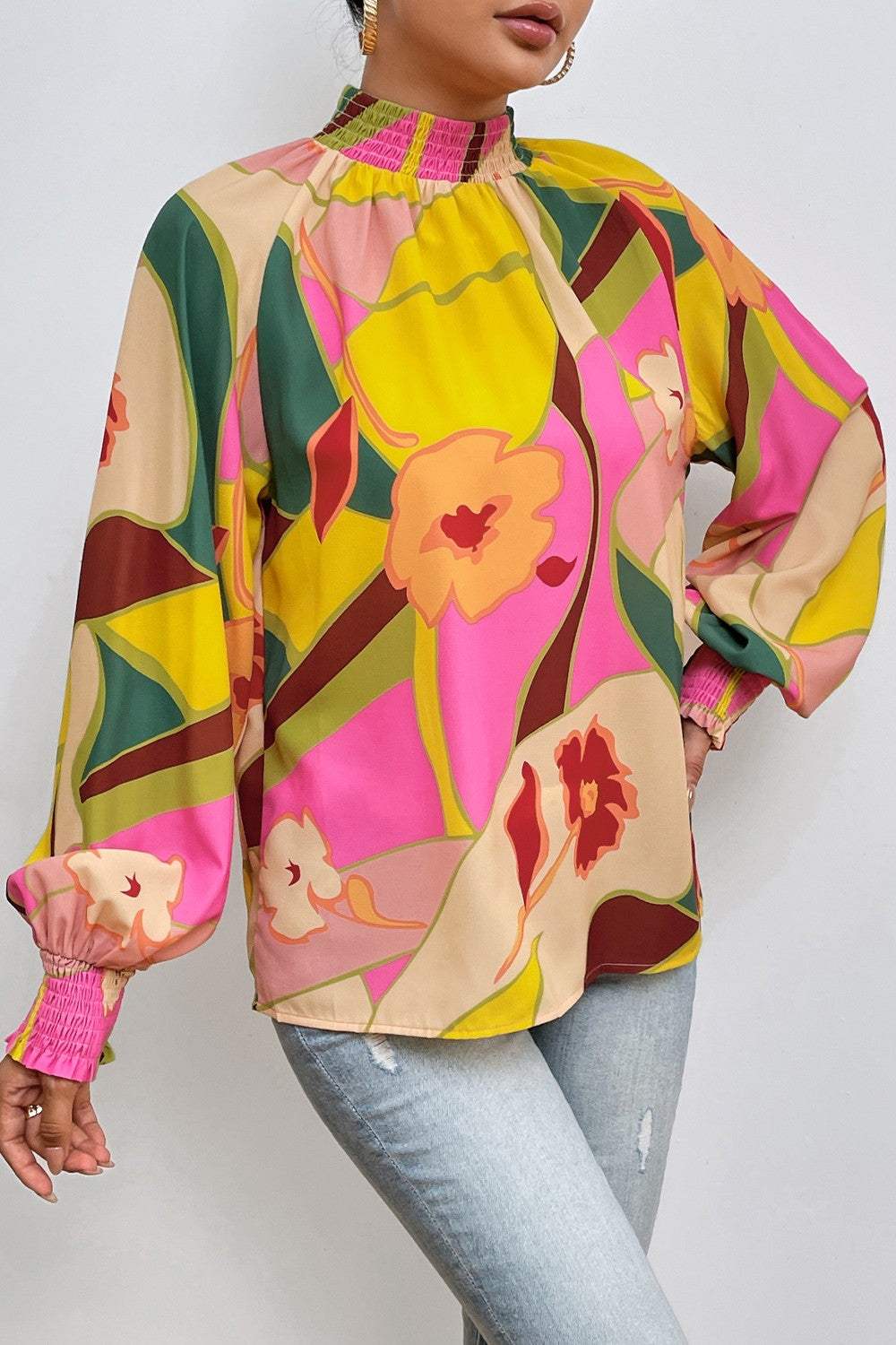 Floral smocked lantern sleeve mock neck blouse in vibrant colors.