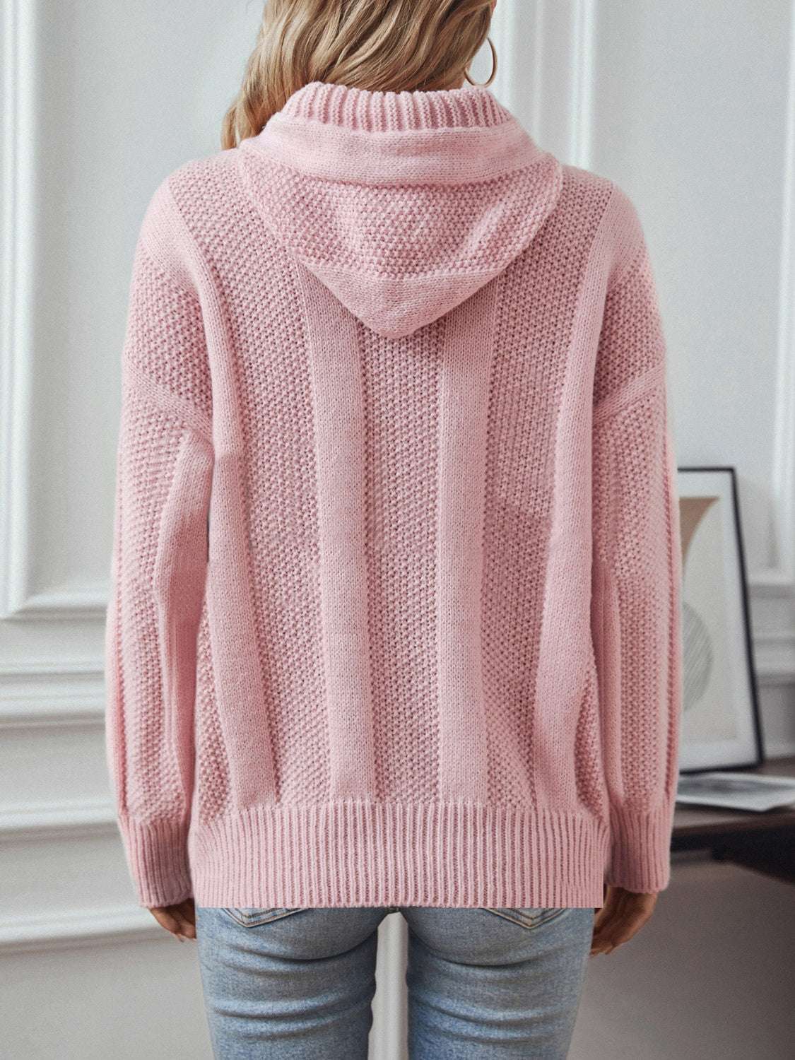 Drawstring long sleeve hooded sweater with decorative button, slightly stretchy polyester, worn by a model.
