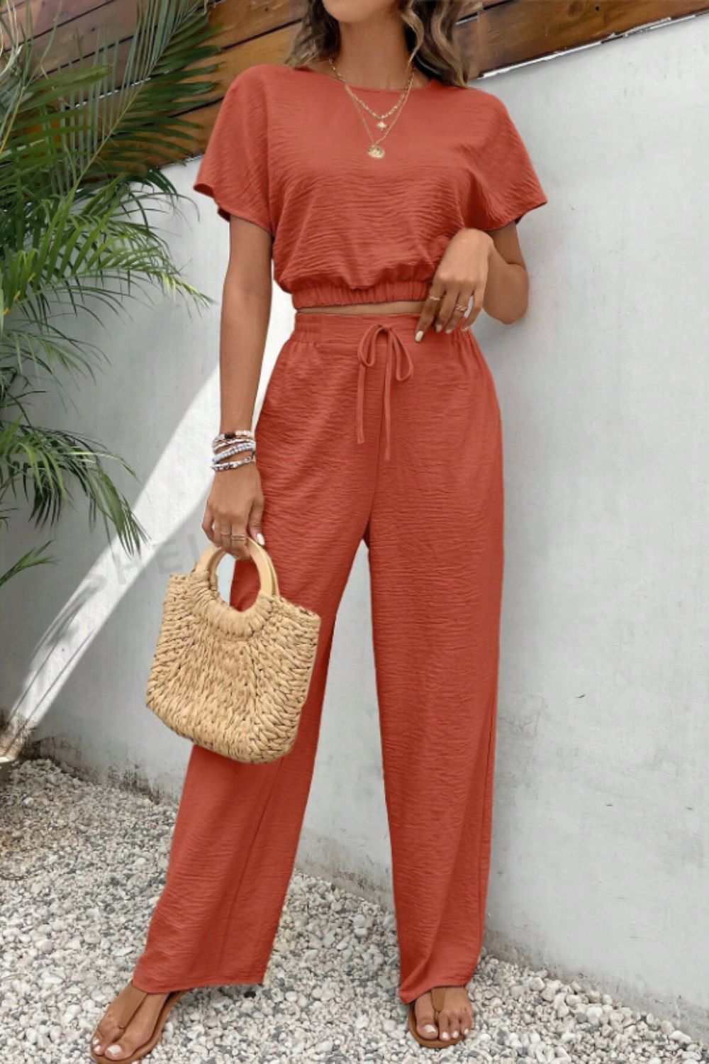 Round neck short sleeve top and pants set with buttoned, tied features, 100% polyester.