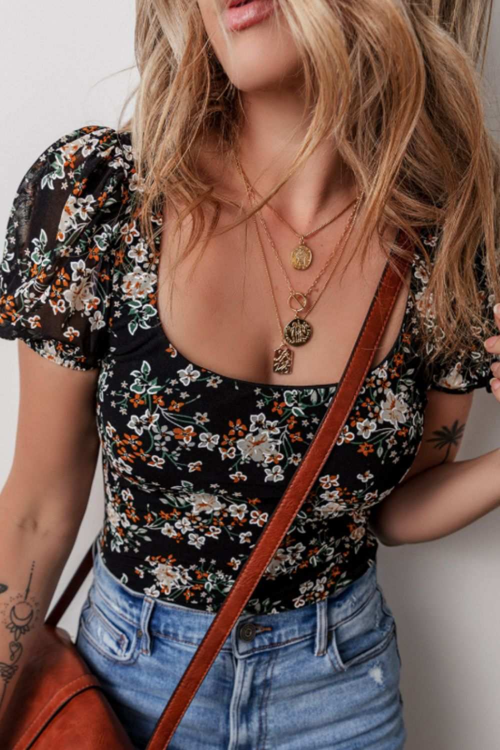 Printed scoop neck short sleeve bodysuit with floral design.