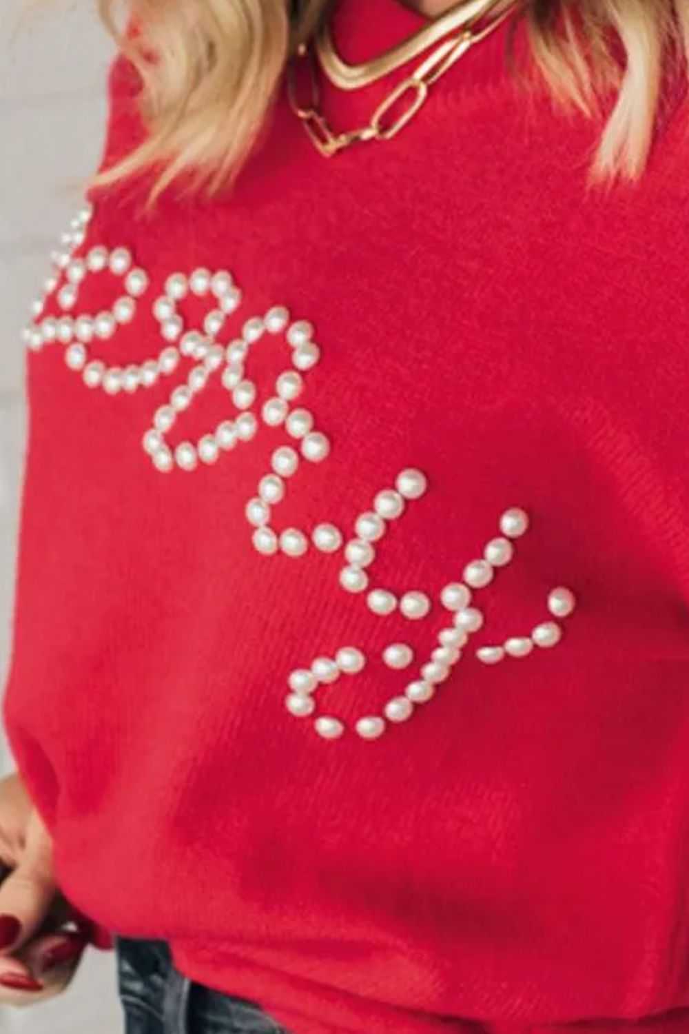 Red letter pearl detail round neck long sleeve sweater on person, showcasing front design.