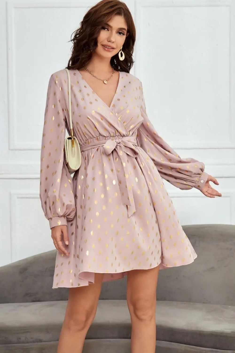 Tied printed surplice long sleeve dress with a waist tie and gold accents.