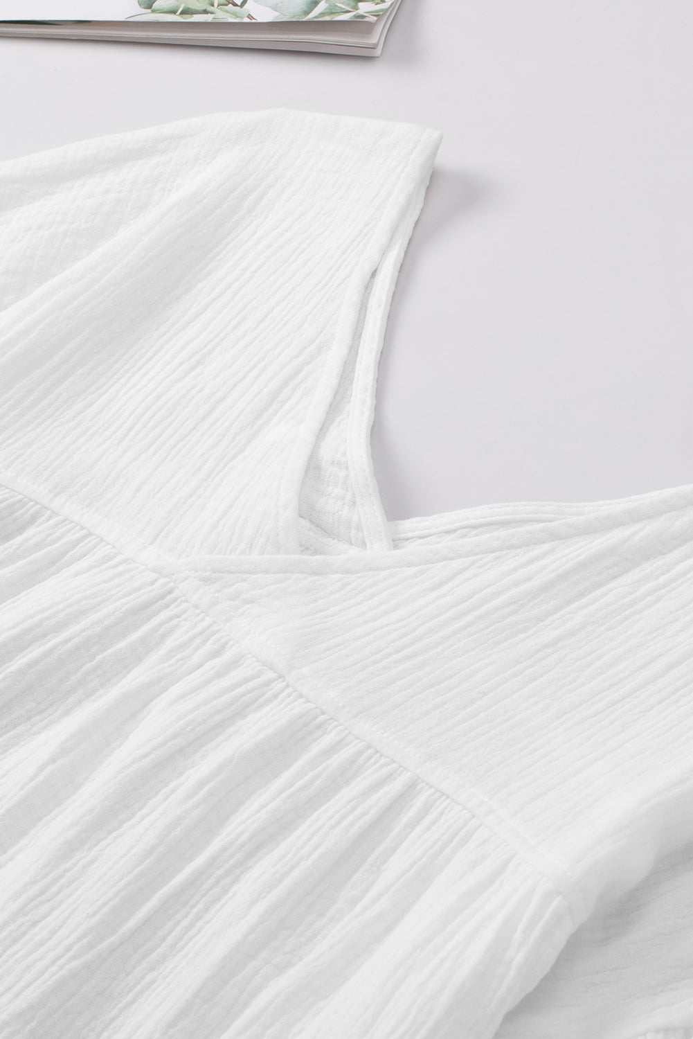 White dropped shoulder V-neck blouse in cotton fabric.