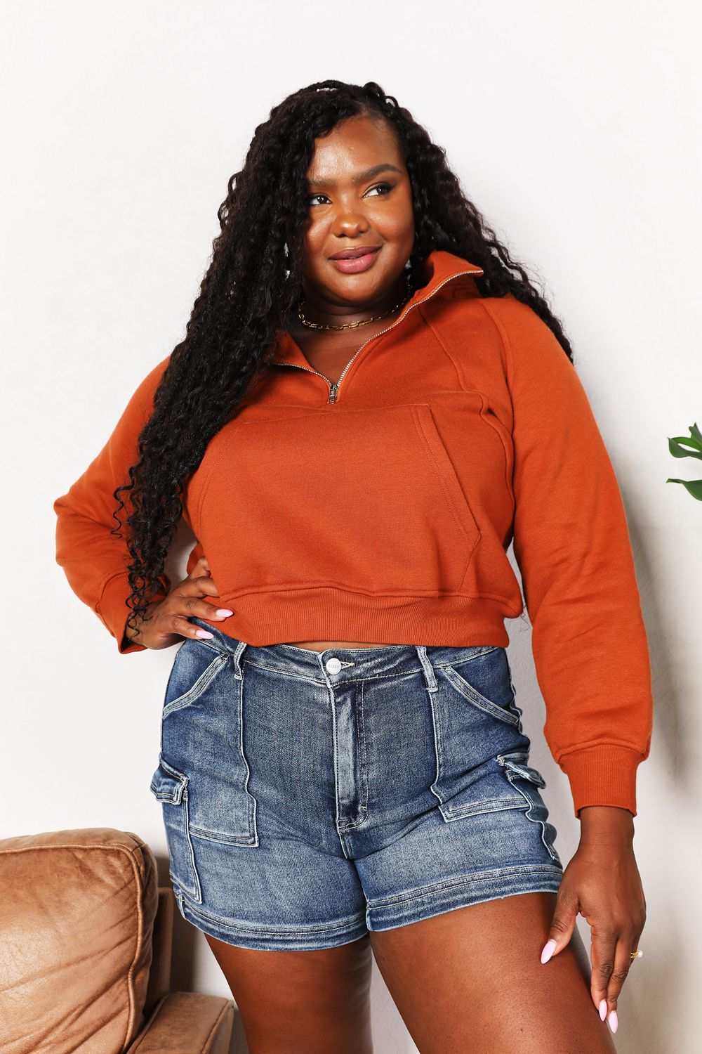 Solid-colored cropped hoodie with half-zip, long raglan sleeves, and collared neck.