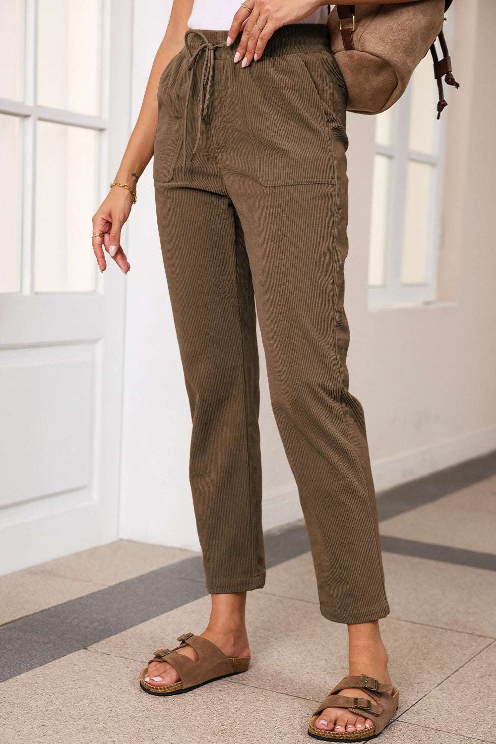 Drawstring straight pants with pockets, 100% polyester, worn by model.